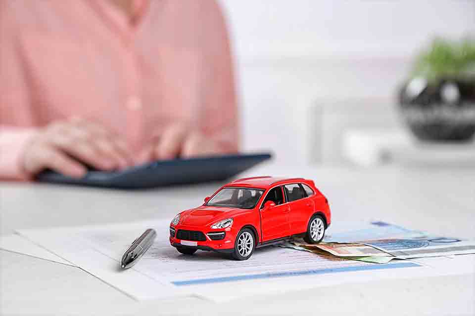 Miniature red car on table