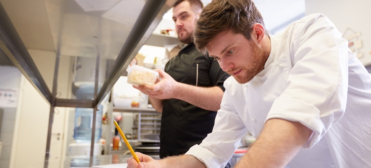 Chef counting restaurant inventory in kitchen