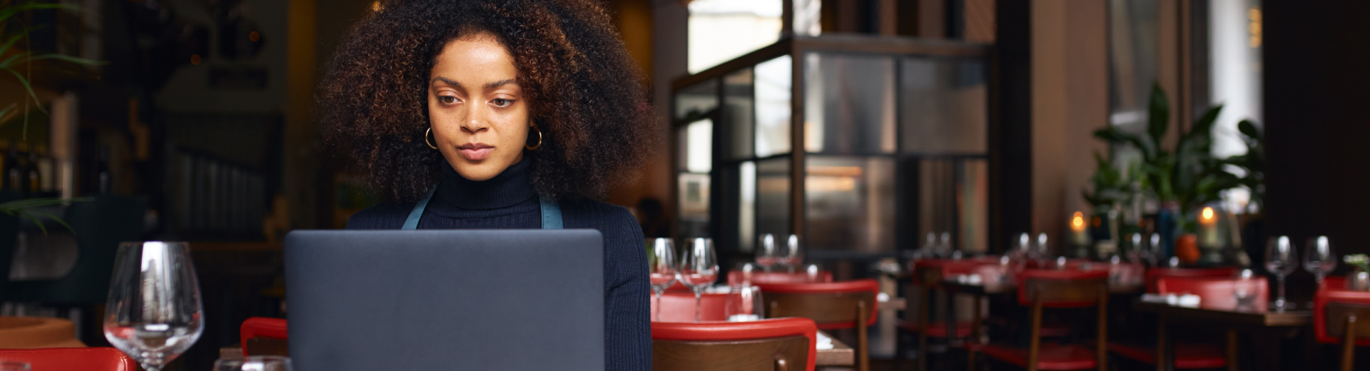Female Restaurant Owner Reviewing Balance Sheet On Laptop