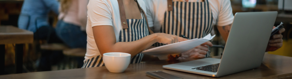 Restaurant managers looking at laptop report
