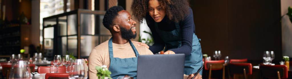Restaurant owners looking at laptop