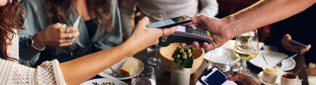 Restaurant patrons paying electronically at table