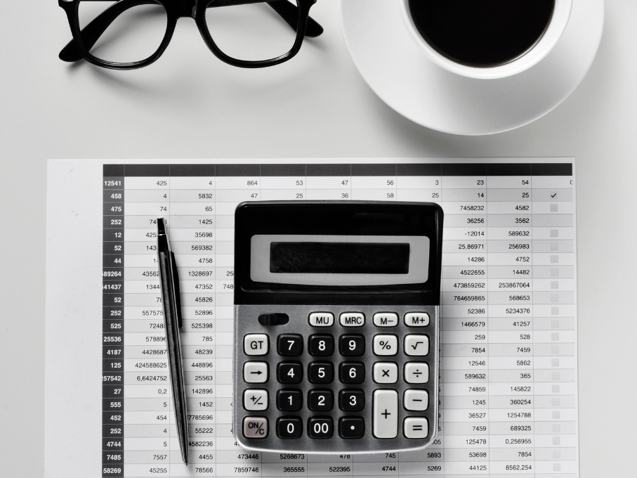Calculator, Pen, Glasses, and Coffee on a table